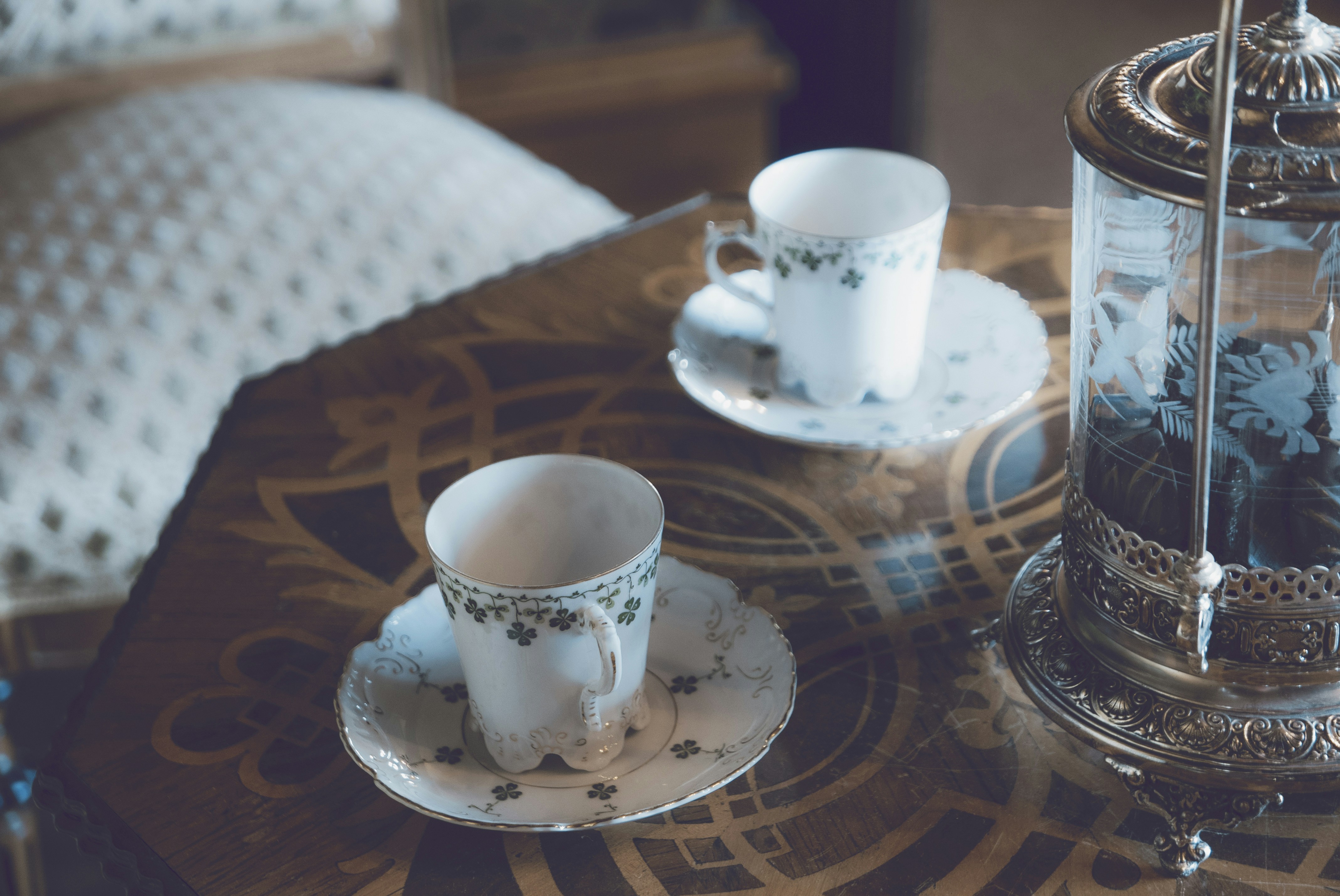 white and black floral ceramic mug on table