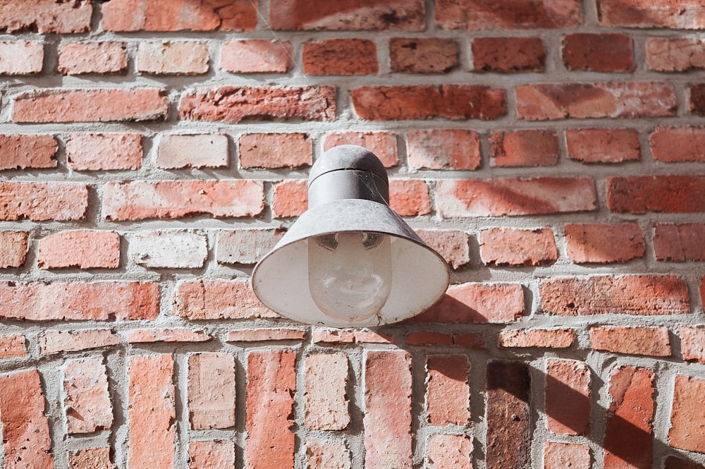 white sconce on brown brick wall