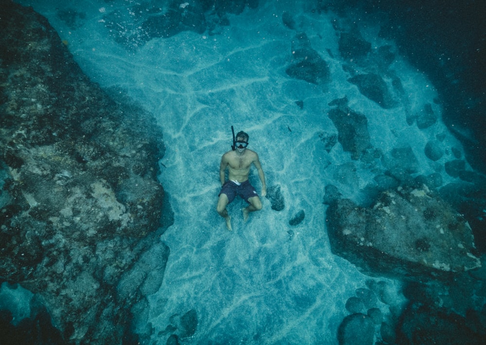 hombre en pantalones cortos negros con snorkel