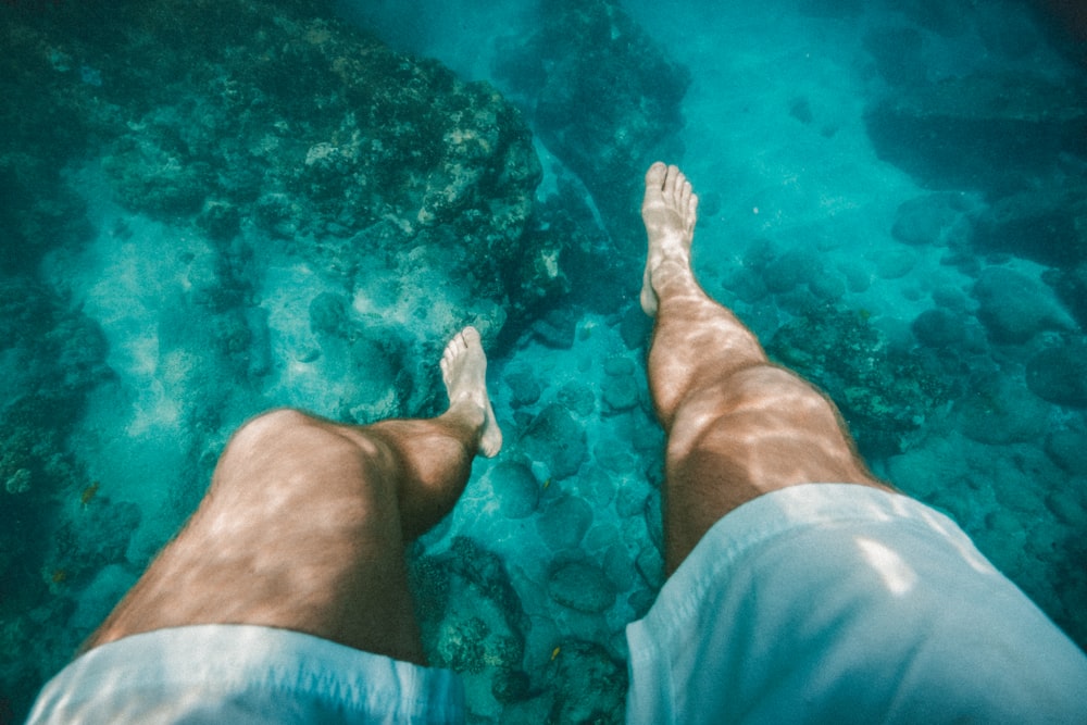 fotografia subaquática de uma pessoa vestindo shorts brancos
