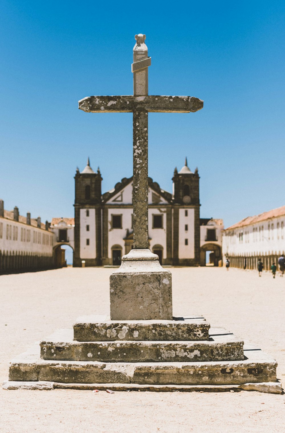 Cruz de hormigón gris frente a la iglesia