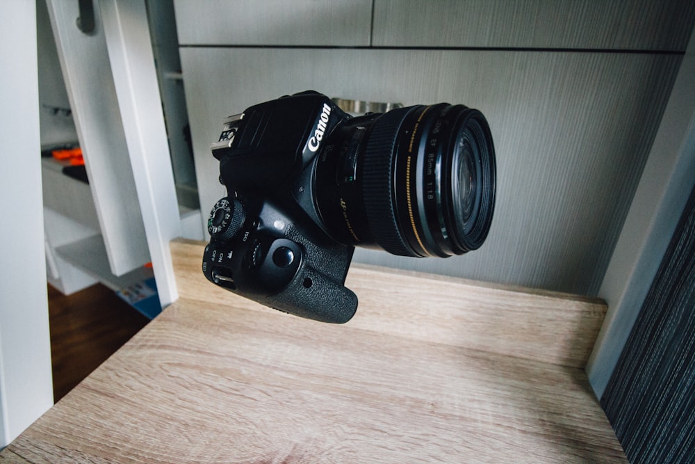 black nikon dslr camera on brown wooden table