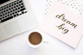 A serene workspace with a laptop, coffee cup, and motivational quotes on the wall.