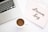 A workspace setting with a laptop, a cup of coffee, and a folder with the phrase 'dream big' written on it. The background features a light color palette with subtle decorative dots.