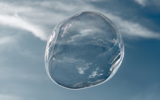 Close-up of players bumping into each other while wearing bright bubble suits with a clear blue sky background