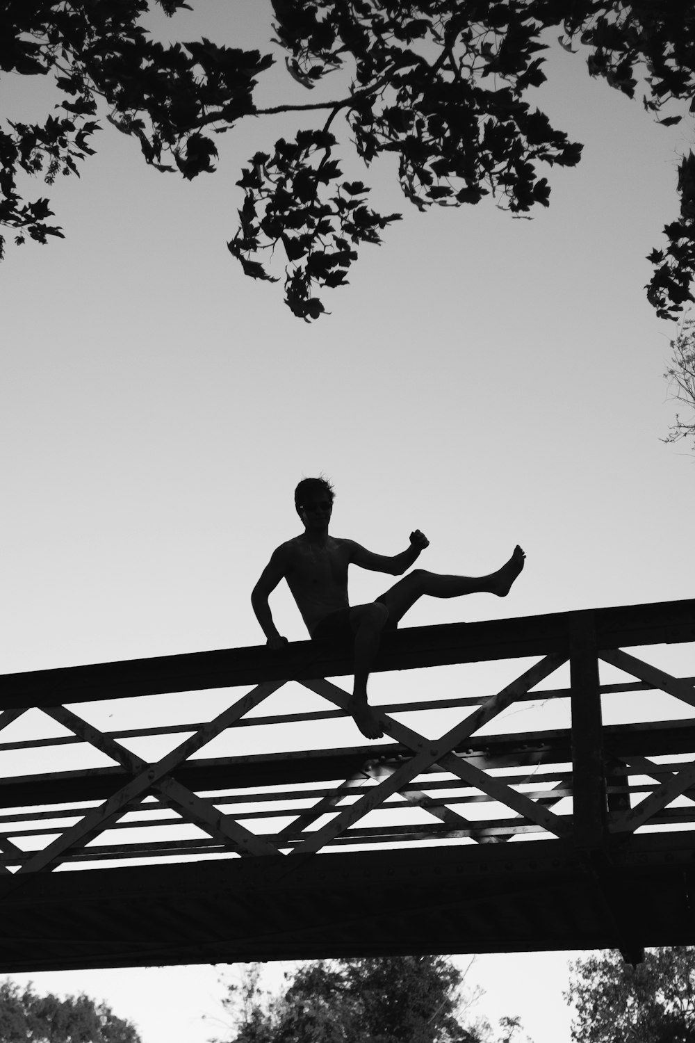 silhouette photo of a man about to jump on footbridge