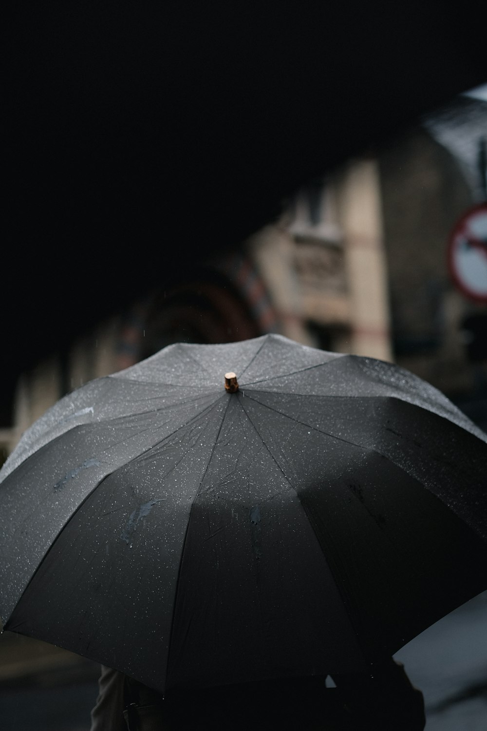 Person unter schwarzem Regenschirm