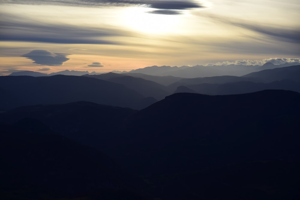 silhouette of mountain under cloudy sky