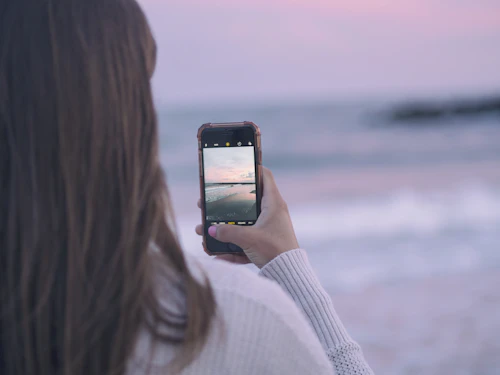 Woman checking her phone by the sea while messaging on a Vanuatu dating app