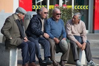 A group of seniors sharing a laugh on a bench near a famous Canadian landmark dusted with snow.