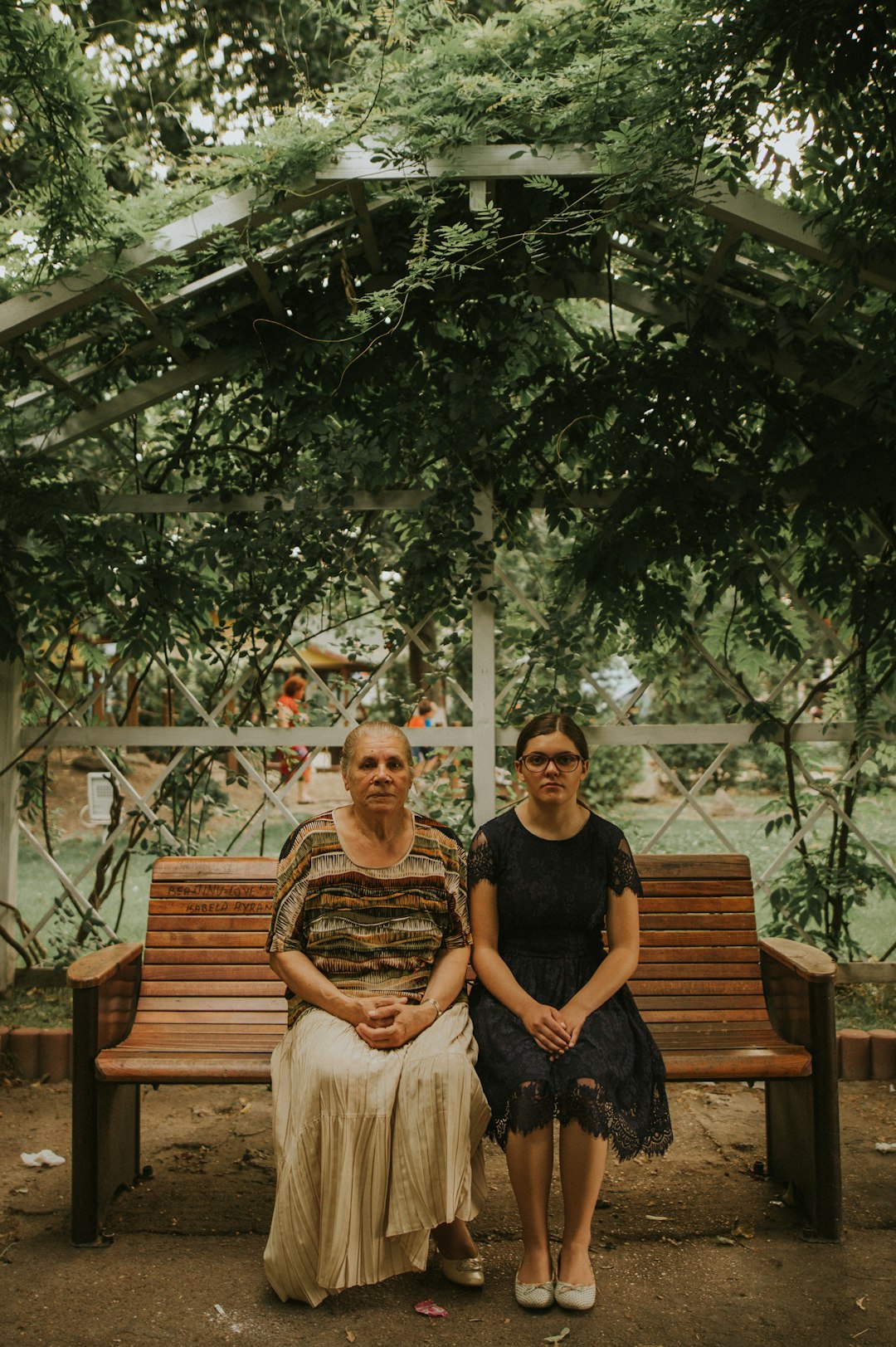 man and woman sitting on brown wooden bench