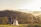 A couple watching the sunrise over misty Himalayan peaks from a wooden deck.