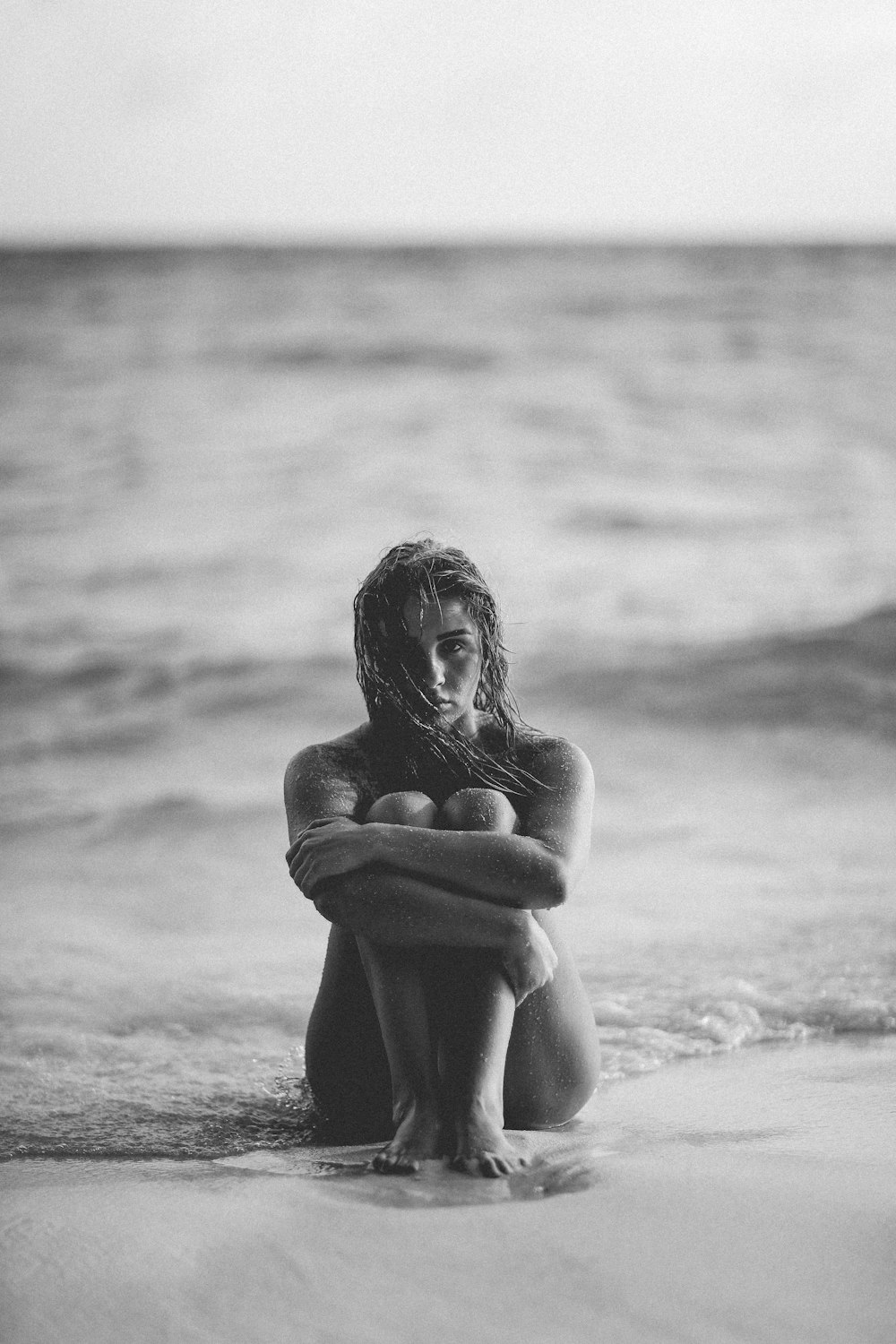 grayscale photo of woman on seashore