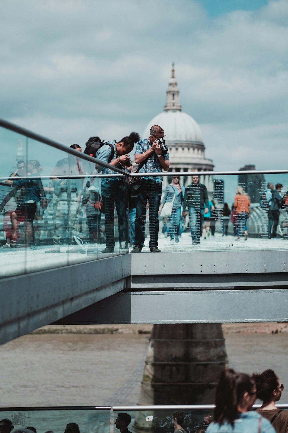 people standing over railings taking a photo