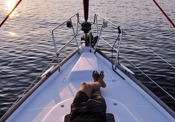 man lying on white boat