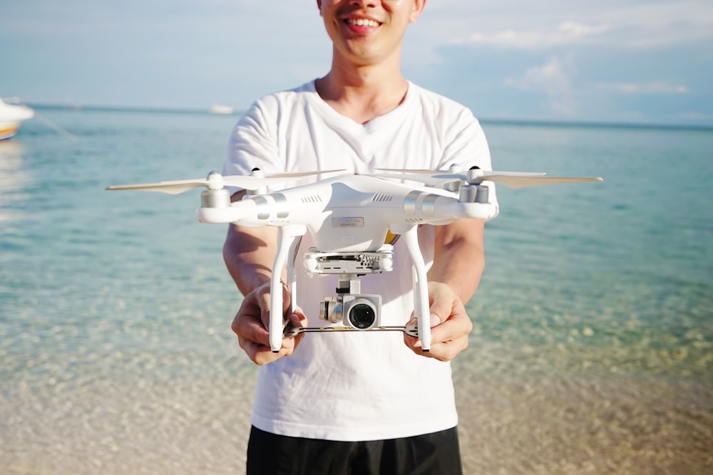 man holding DJI Phatom Professional on beach