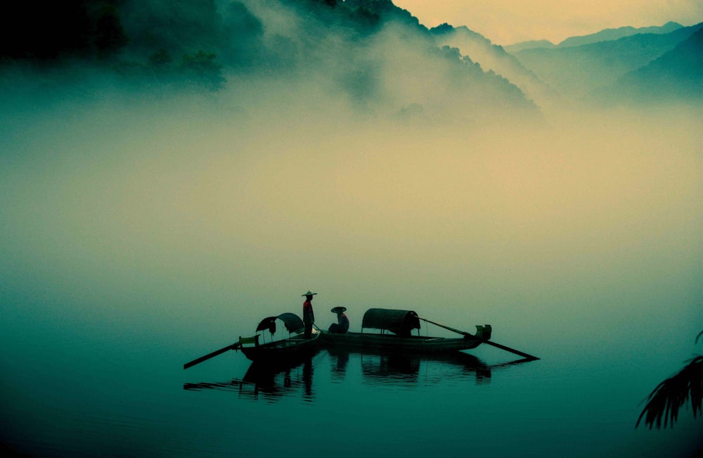 two persons riding on boats