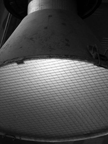 Detailed view of corrosion-resistant coating on an aluminum lamp housing under bright lighting.