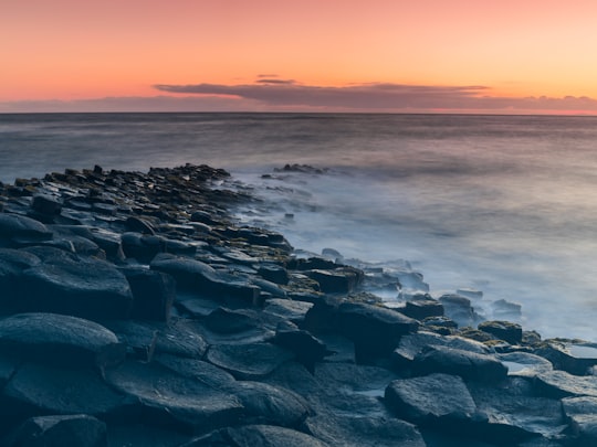 rock formations near body of water in Giant's Causeway United Kingdom