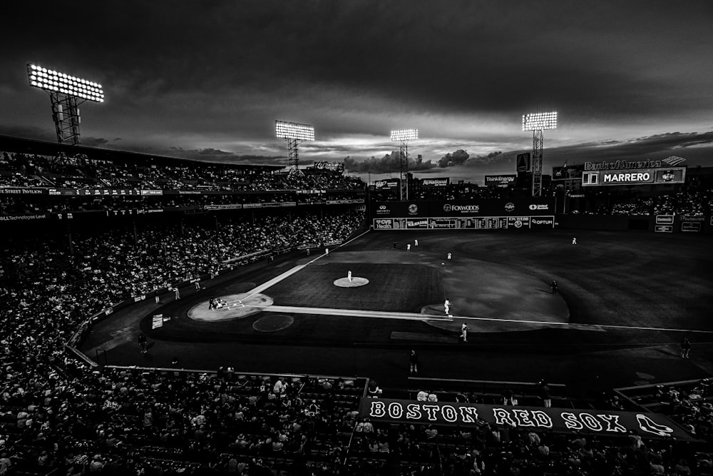 Fotografía en escala de grises de un campo de béisbol con gente en las gradas
