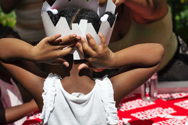 Close-up of a child with detailed knight face paint and a paper crown