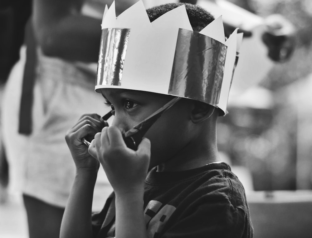 grayscale photography of boy taking off sunglasses