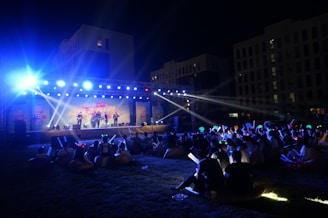 Nighttime event with illuminated stage and audience enjoying the show.