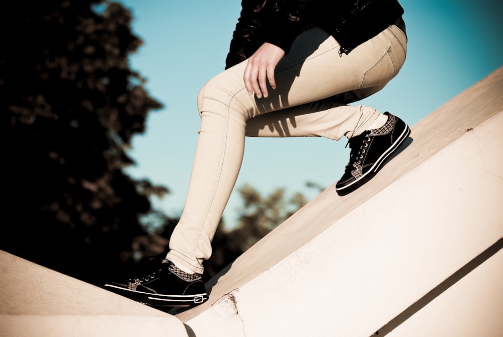 person wearing beige pants sliding on slope