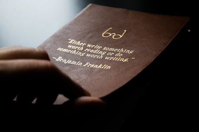 Close-up of hands firmly holding a leather-bound ledger, representing careful capital management.