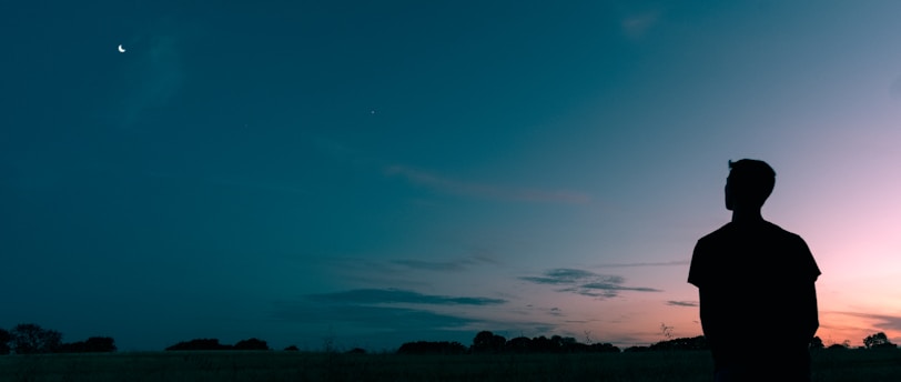 silhouette of man looking star during sunset