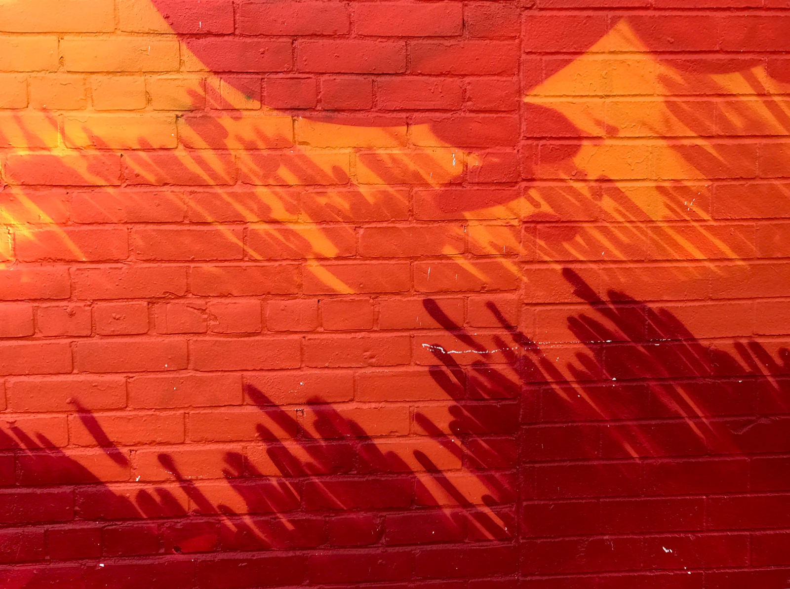 Mur de briques peint en rouge et orange