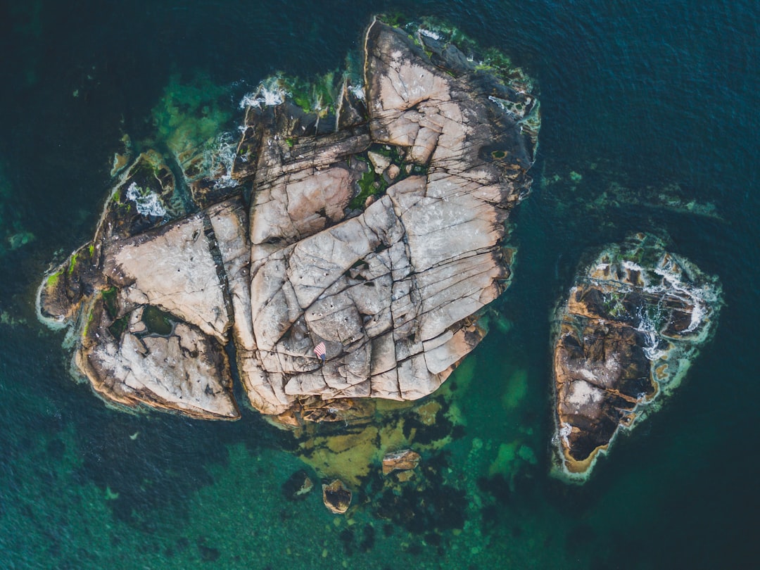 brown rock formation on water aerial photogrpahy