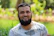 Portrait of a bearded man smiling outdoors with fresh, natural lighting.