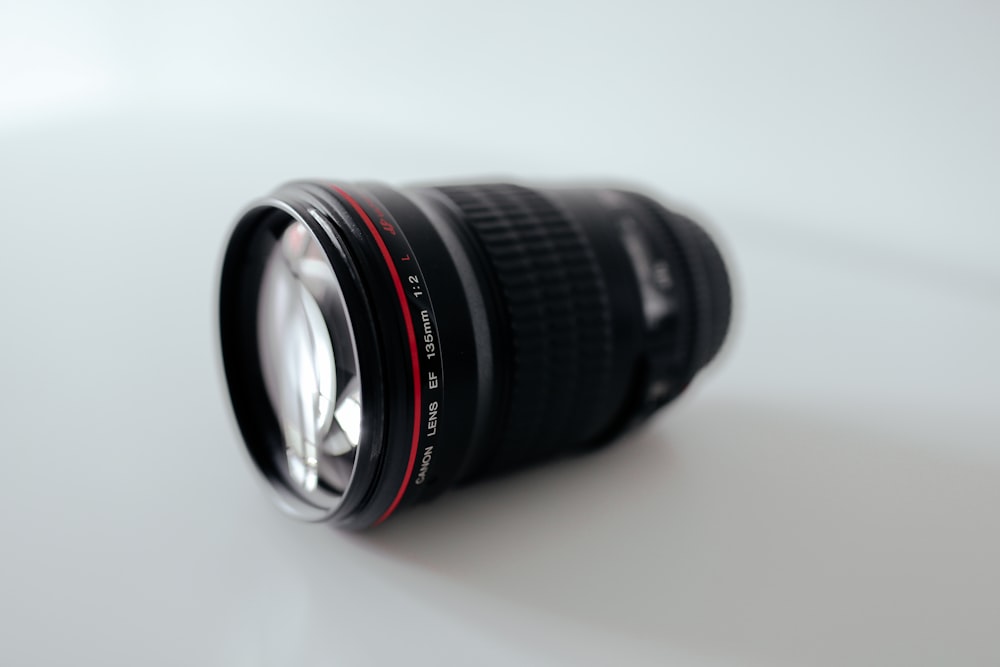 closeup photography of black camera lens on white surface