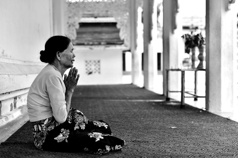 Frau betet in Graustufenfoto