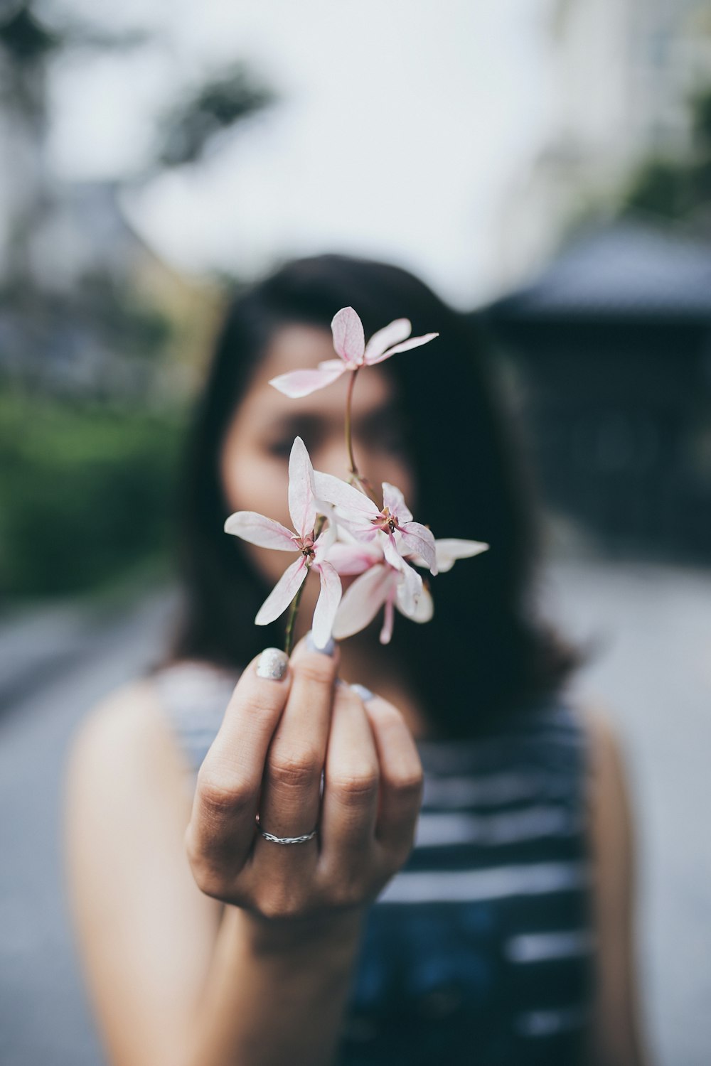 femme tenant une fleur rose