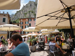 A welcoming Spanish café terrace with sunlit tables and people enjoying lively conversations.