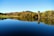 A serene landscape featuring a calm lake surrounded by trees, symbolizing tranquility and mental wellness.