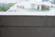 Close-up of the em legacy cap resting on a spray-painted brick ledge with colorful urban textures around.