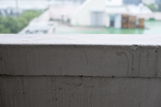 Close-up of the em legacy cap resting on a spray-painted brick ledge with colorful urban textures around.