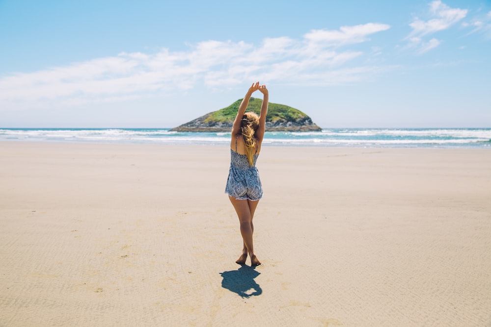 woman on seashore near island under blue sky