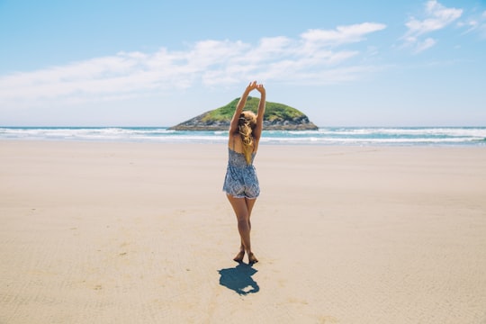 woman on seashore near island under blue sky in Tofino Canada