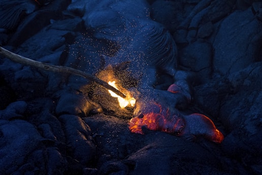 Close-up of flowing molten lava glowing bright orange against a dark background.