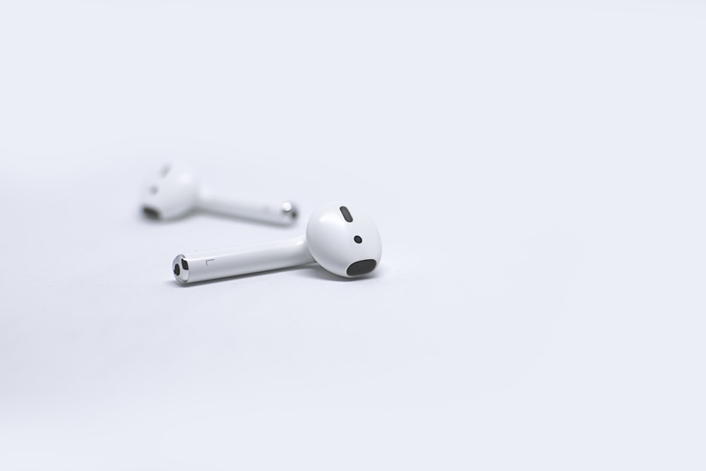 Apple AirPods on white surface