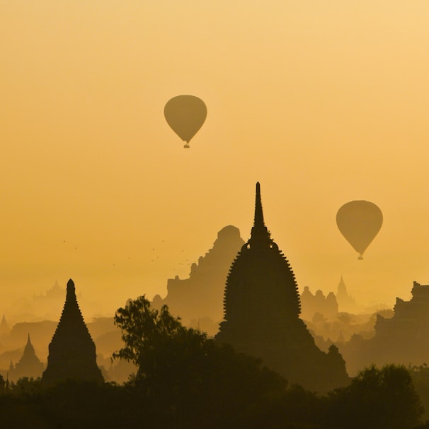 silhouette of two hot air balloons near temple