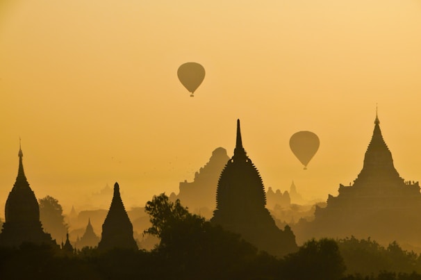 silhouette of two hot air balloons near temple