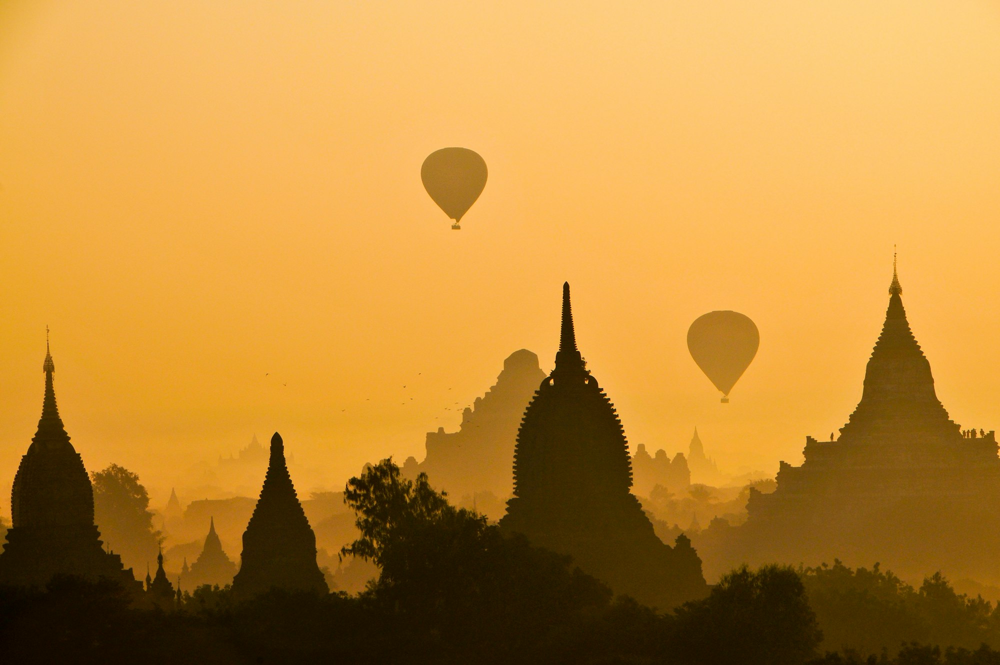 This photo was one of many taken at the Sunrise Pagoda in December of 2011.This was my first trip to Burma, an eye opening trip for sure. In the ancient capital of Bagan, a small boy saw me early in the morning and said, “where you are going?” I said, “to the sunrise Pagoda…”  He said, “I take you a shortcut....” It was a shortcut indeed and after climbing to the second level of this ancient pagoda the light was perfect, the balloons came and viola! I gave my tour guide a small reward for his efforts to get me there in time. I was happy to capture this shot and want to share it with the world.
