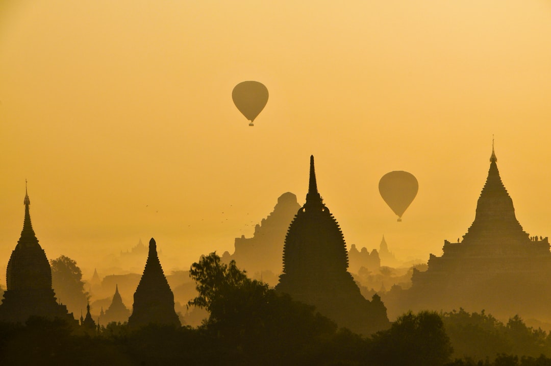 silhouette of two hot air balloons near temple