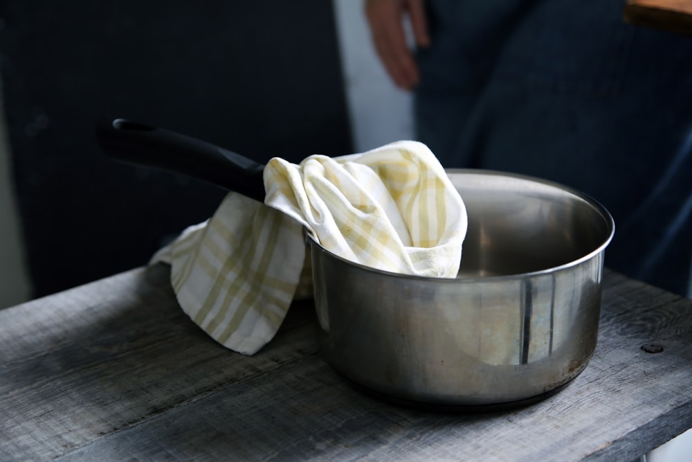 yellow and white textile on top of gray saucepan