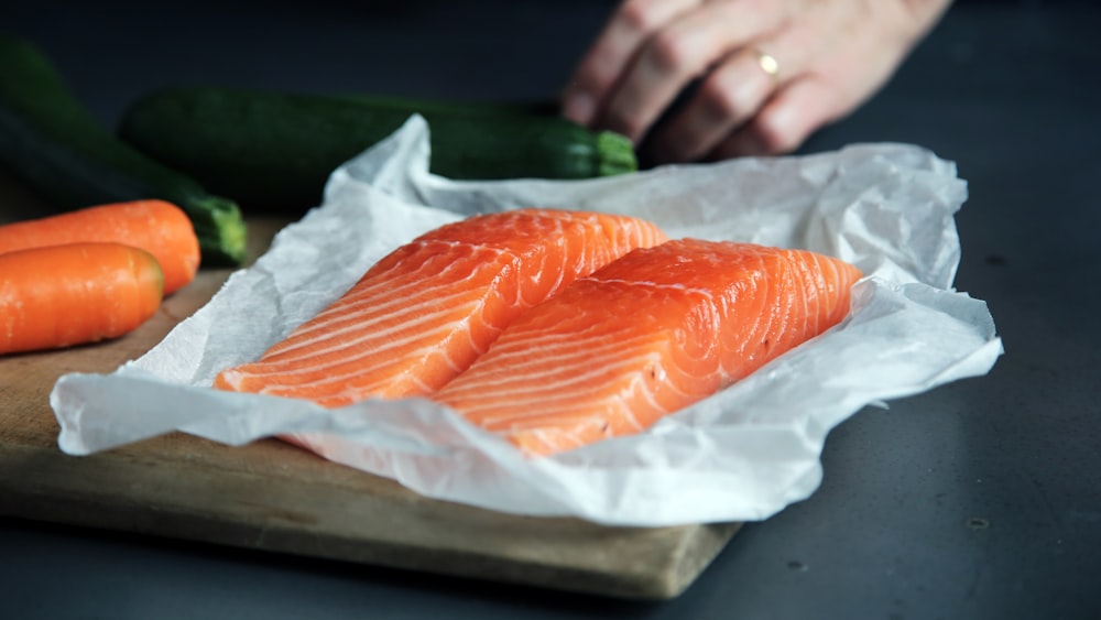 raw salmon fillets on brown chopping board